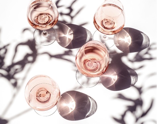 Glasses of pale pink rosé wine from Provence on a sunlit terrace, reflecting the region’s light, elegance and Mediterranean lifestyle.